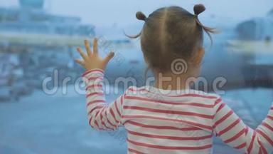 小女孩看着窗外的飞机，后面。