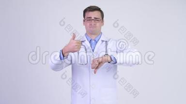 年轻英俊的医生在竖起大拇指和大拇指之间做出选择