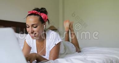 年轻女子用笔记本电脑进行视频聊天称美女为躺在床上的早晨