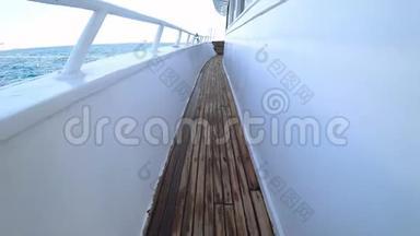 镜头缓缓升起，<strong>露出</strong>了矗立在海中的游艇的长甲板。 木板做成的长木地板