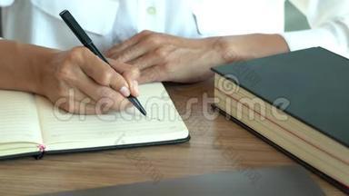 4k视频，人手握笔写做清单或业务数据用笔在笔记本电脑乳制品
