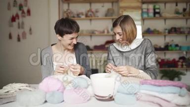 两个快乐的女朋友在家里的工作室玩<strong>毛线</strong>衣
