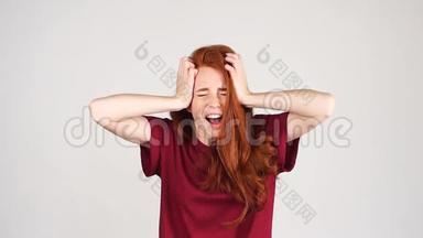 尖叫的红头发女孩穿着毛衣，闭着<strong>眼睛捂</strong>住耳朵，慢动作。
