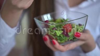 优雅的女商人在她的工作场所吃午饭的4K视频。 在办公室吃蔬菜沙拉的女人。 4k