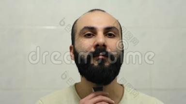 亚美尼亚男子用电动剃须刀刮胡子
