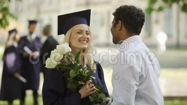 男朋友送花给他的女毕业生，拥抱特殊场合