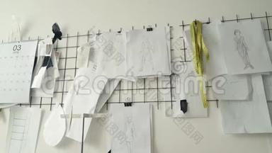 服装设计草图，黑白模板和画钉在工作室白色墙壁上。 规划新衣服