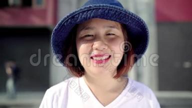 在中国北京的唐人街旅行时，一个开朗美丽的年轻亚洲背包客女人对相机微笑感到快乐。
