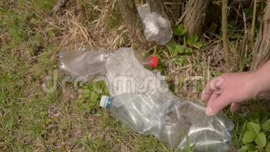 地面塑料的污染.. 垃圾收集。 手清理塑料垃圾.. 环境保护。 塑料瓶