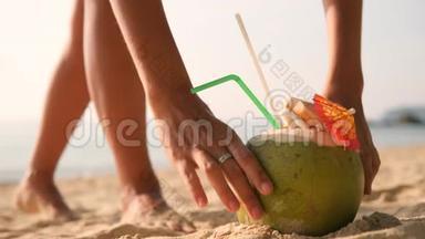 女人在热带海滩游泳后，从沙滩<strong>上拿起</strong>美味的新鲜泰国椰子鸡尾，然后走开。 4K