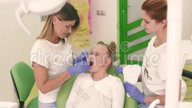 小女孩穿着白色连衣裙坐在<strong>牙医</strong>办公室微笑着看着镜子。 带手套的<strong>牙医</strong>