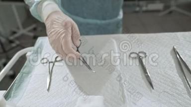 手术结束后，外科医生从手术台上取出手臂上的医疗器械。 医生将无菌工具放入