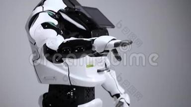 现代机器人技术。 白色现代机器人在一个明亮的工作室。 安卓系统挥舞着问候的手，问候观众