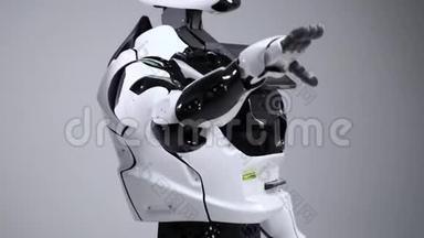 现代机器人技术。 白色现代机器人在一个明亮的工作室。 安卓系统挥舞着问候的手，问候观众