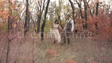 一对相爱的夫妇牵着手在秋天的公园里跑来跑去，慢镜头拍摄