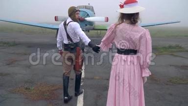 一个穿着粉红色衣服和帽子的女人护送飞行员去打仗，慢镜头射击
