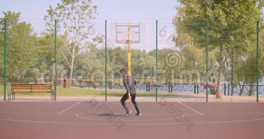 年轻活跃的非裔美国男篮球运动员在户外向篮筐投掷球的特写镜头