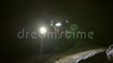 两个年轻的徒步旅行者探险者困在黑暗洞穴的窄洞里