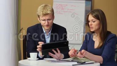 办公会议男人展示图表装置，女人写下