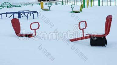 孩子们在冬天的雪地里`玩跷跷板和旋转木马。 相机是静态的。