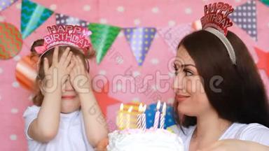 生日快乐。 母亲和女儿在聚会上吹灭蛋糕上的蜡烛，许愿。 妈妈祝贺、拥抱和
