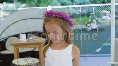 快乐的小女孩带着一束野花，嗅着，微笑着。 4K