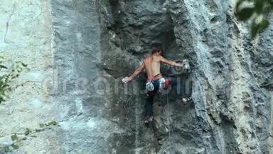 后景强壮的肌肉男攀岩者在<strong>户外</strong>运动路线上<strong>攀登</strong>垂直悬崖