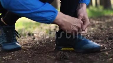 人在森林道路上奔跑时系鞋带. 在森林里用手系鞋带的特写镜头