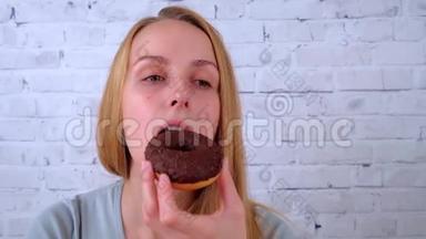 快乐的年轻女人吃巧克力甜甜圈<strong>喝</strong>茶