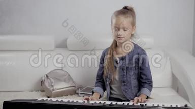 女孩`钢琴键盘上的手。 女孩弹钢琴，合上钢琴。 手放在钢琴的白键上