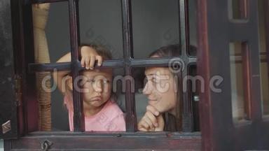 妈妈和小女儿正带着无聊的情绪望着窗外..