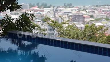 无限泳池俯瞰城市天际线-彩色房屋和酒店、树木、海洋和天空的美景