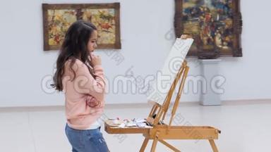 女人站在画布前看着集中。