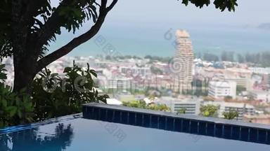 无限泳池俯瞰城市天际线-彩色房屋和酒店、树木、海洋和天空的美景