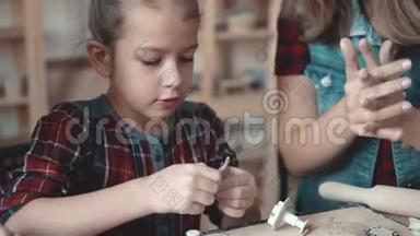 一个严肃的小女孩从陶艺课上做了一个陶艺。