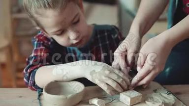小女孩在做一盘粘土。 老师帮助孩子完成任务