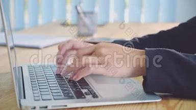 在办公室背景下的笔记本电脑上工作的人手。 办公室里的一位年轻妇女在<strong>键盘</strong>上拨<strong>文件</strong>。