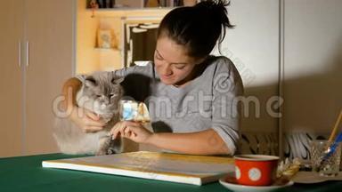 漂亮的女孩和她的<strong>宠物</strong>玩。 一位年轻的艺术家试图教猫画画。 <strong>主人</strong>和他们有趣的动物。