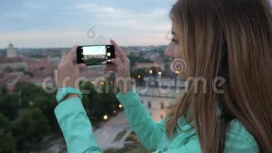 一个甜美的女孩，一个观景台上的旅行者，为城市拍照。