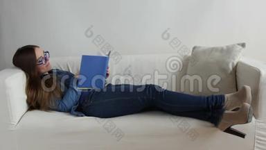 女人躺在家里的沙发上看书。 全高清