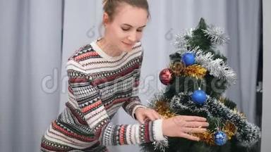 穿着圣诞毛衣、面带微笑、在圣诞树上装饰玩具的漂亮快乐女人。射入