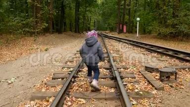一个小<strong>女孩</strong>走在铁轨上。
