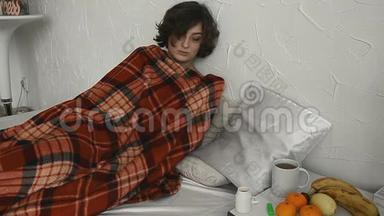 一个生病的女人躺在毯子下面测<strong>量体温</strong>