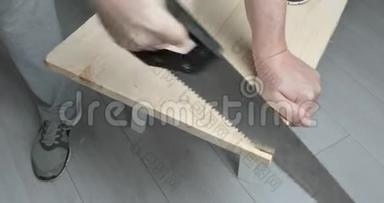 一个人用手锯锯木板