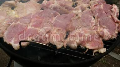 大型美味的生肉牛排在烧烤炉上烤过煤，在一个小的户外烧烤。