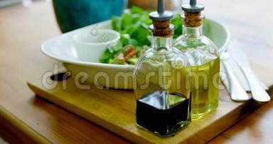 4k餐厅桌子上的一碗沙拉和橄榄油瓶