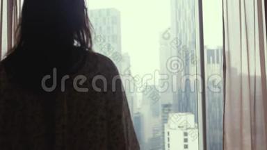 布鲁内特女士走到窗前，站在大窗户旁边，望着城市建筑上的公寓。 3840x2160