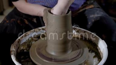 在一个<strong>生产车间</strong>的陶轮上，用粘土将陶器主成形制成花瓶。