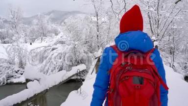 年轻女子穿过大桥过河，用智能手机拍了一张美丽<strong>的</strong>冬天<strong>雪的照片</strong>