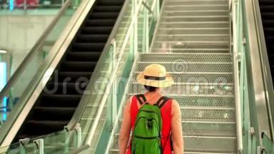 那个穿着红色连衣裙和帽子的女人在机场上楼。 机场。 戴着帽子和背包的女人走了